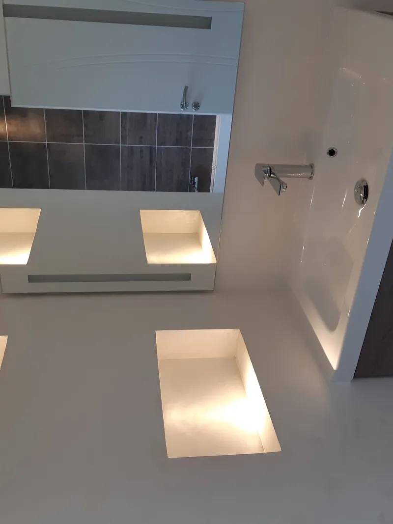 Salle de bain avec niches murales éclairées et miroir lumineux